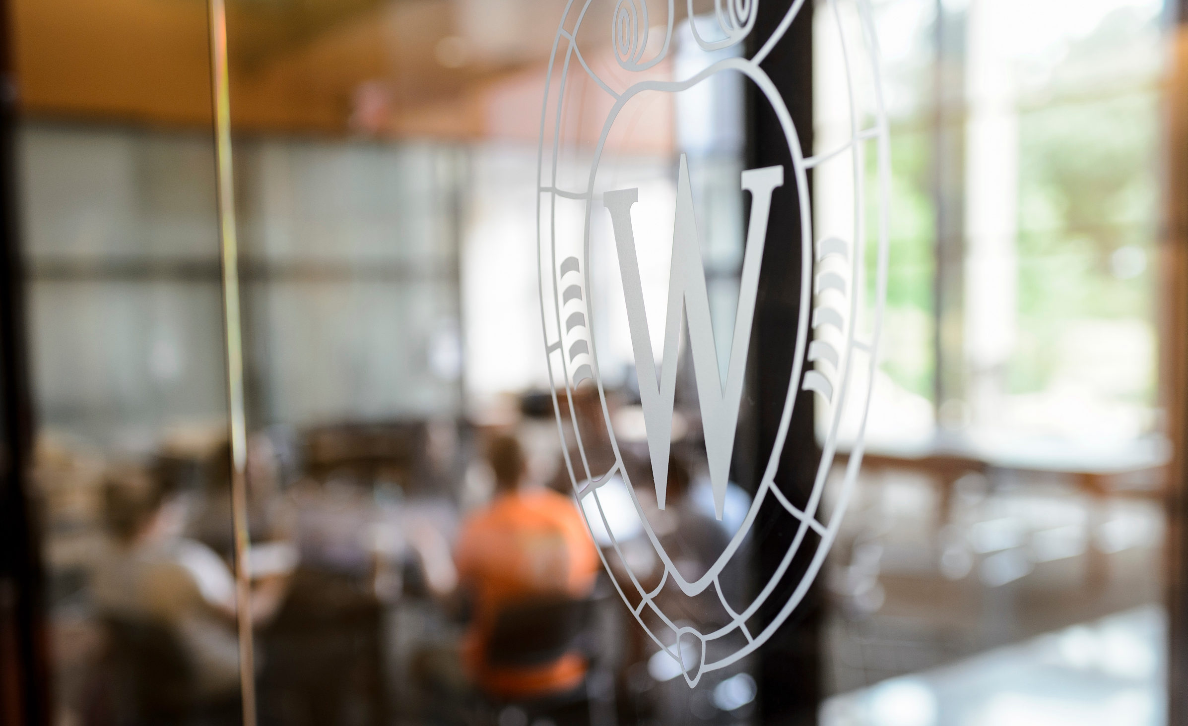 white outlined Wisconsin crest logo on a glass window