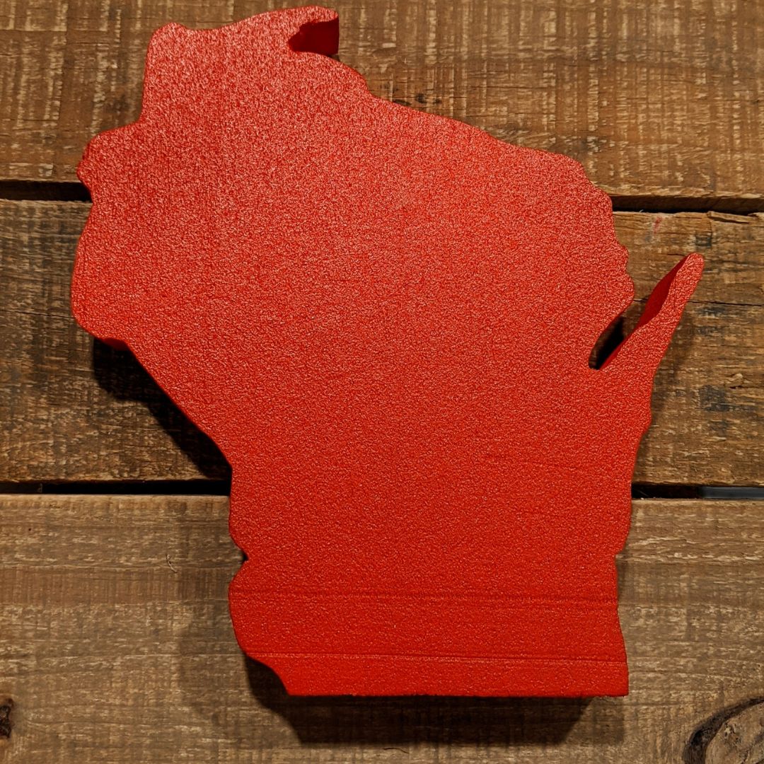 a red Wisconsin cutout sitting on wooden planks