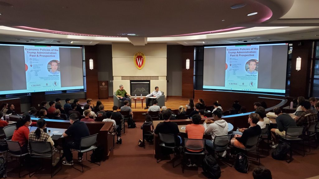 A photo of the speaker, Casey Mulligan, and Ananth Seshadri seated on stage during the fireside chat.
